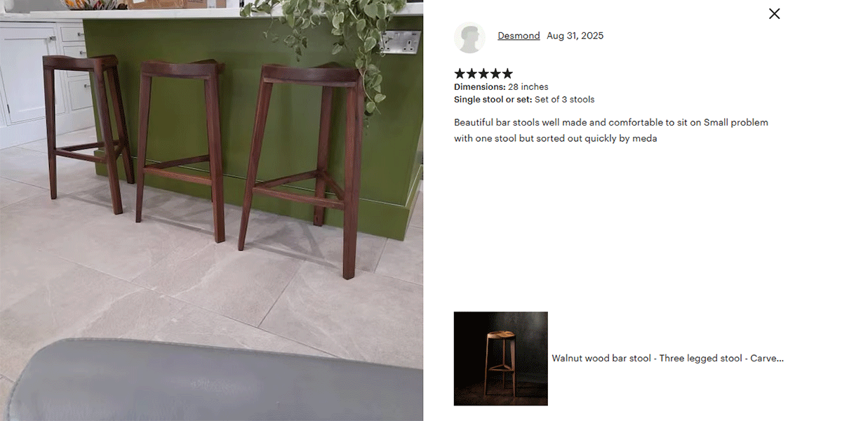 Wooden bar stools in front of a green bar with a customer review on the right.